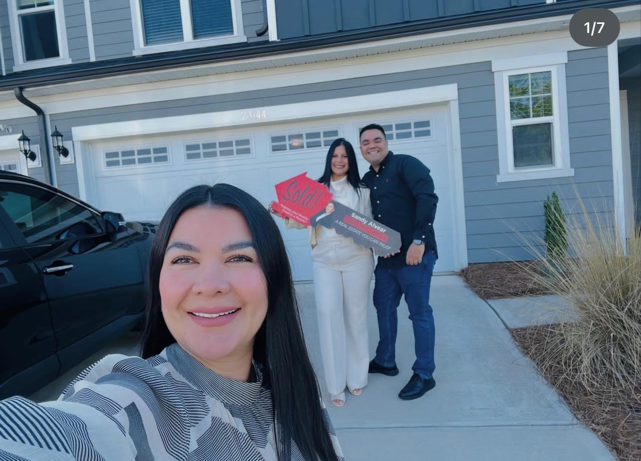 Sandy Alvear selfie with clients at sold new construction home